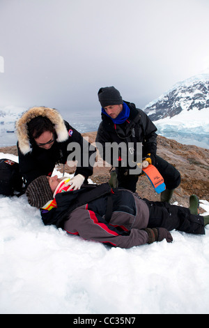 Un chirurgien traumatologie s'occupe d'un alpiniste tombé sur la face de la montagne de Neko Harbour, l'Antarctique Banque D'Images