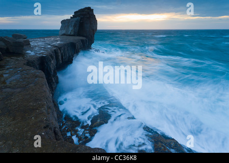Les vagues déferlent sur Pulpit Rock, à la pointe de Portland Bill, Dorset, au coucher du soleil en novembre. Banque D'Images