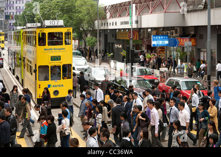 La densité du trafic des piétons et des véhicules aux heures de pointe dans les rues de Hong Kong Banque D'Images