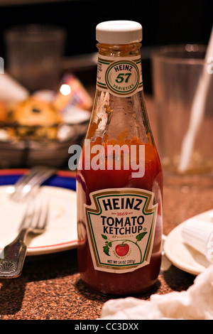 14oz bouteille de ketchup Heinz assis sur table après un repas Banque D'Images