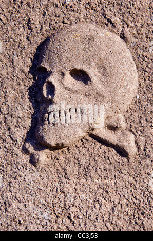 Tête de mort primitive relief sur l'ancien cimetière fence Banque D'Images