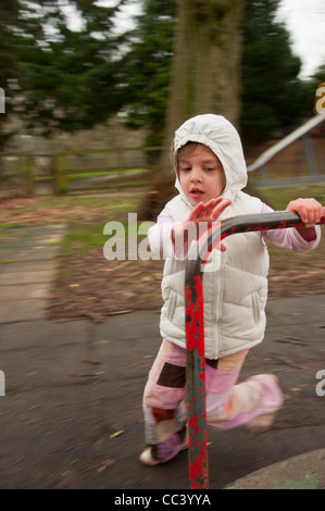 Jeune fille jouant sur le rond-point de jeux Banque D'Images