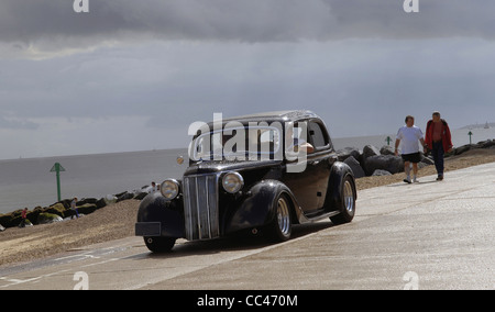 Une belle voiture classique, un pilote Ford, des croisières le long de la mer à Coquelles pendant la croisière 2011 NASC. Un ciel en colère après la pluie Banque D'Images