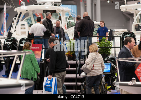 Les acheteurs potentiels et de personnes exploration seulement vérifier les embarcations à moteur à l'assurance Progressive New York Boat Show Banque D'Images