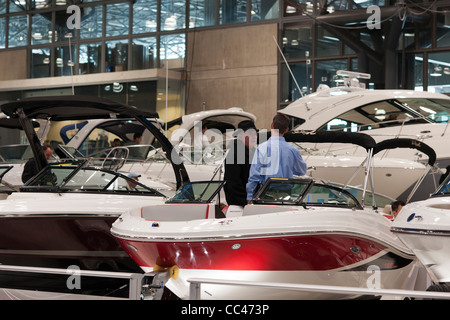 Les acheteurs potentiels et de personnes exploration seulement vérifier les embarcations à moteur à l'assurance Progressive New York Boat Show Banque D'Images