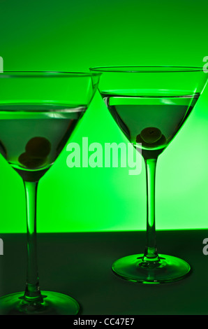 Une composition artistique de deux cocktails rafraîchissant sur un bar en face d'un fond vert.