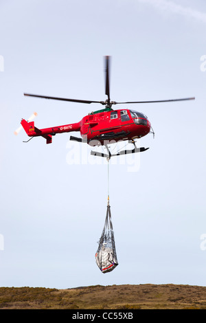Red hélicoptère transportant dans un filet, Cornwall, UK Banque D'Images