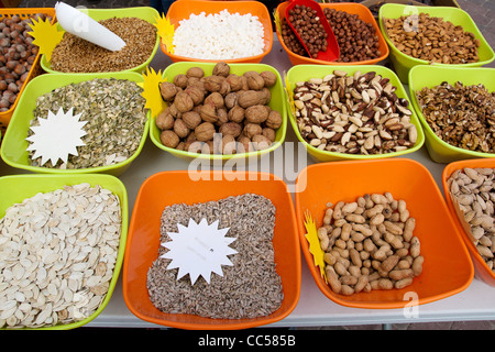 Les noix et les graines dans des récipients de couleur en vente sur le marché Banque D'Images