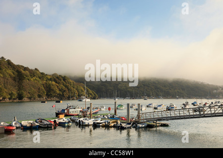 Fowey, Cornwall, Angleterre, Royaume-Uni, Grande Bretagne. Bateaux amarrés sur la rivière Fowey avec sea mist clearing sur les collines Banque D'Images