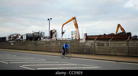 Des promenades cyclistes passé une ferraille où de vieilles voitures et véhicules n'est écrasé Shoreham Harbour West Sussex UK Banque D'Images