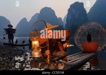 Les pêcheurs chinois avec les cormorans à l'aube sur la rivière Li et de hautes montagnes formation karstique de la Chine yangshuo Banque D'Images