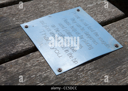 Une "Prière de ne pas nourrir les mouettes' signe sur un banc de la plage à Weston-Super-Mare, en Angleterre. Banque D'Images