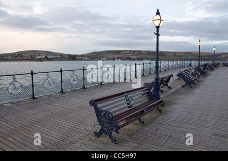 Bancs en fonte, lampadaires et des garde-corps, sur la promenade de la jetée victorienne à Swanage. Dorset, Angleterre, Royaume-Uni. Banque D'Images