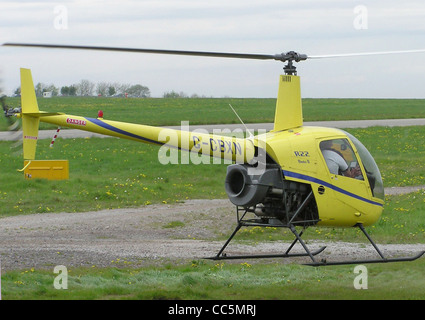 Robinson R22 BETA II (hélicoptère G-CBXN, construit en 2002) le vol stationnaire à l'aéroport international de Bristol, Bristol, Angleterre. Banque D'Images