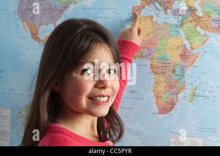 Jeune fille en pointant sur les différents pays sur la carte du monde Banque D'Images