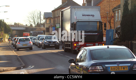 Livraison d'un camion garé sur un maladroitement occupé route étroite entraîne la congestion routière dans la région de Huntingdon, Cambridgeshire. Banque D'Images
