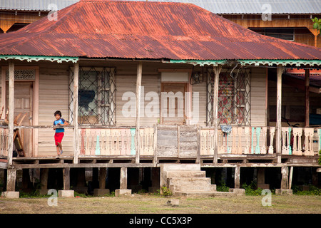 Petit garçon et typique en bois caraïbes accueil dans le petit village de Cahuita, côte des Caraïbes, Costa Rica, Amérique Centrale Banque D'Images