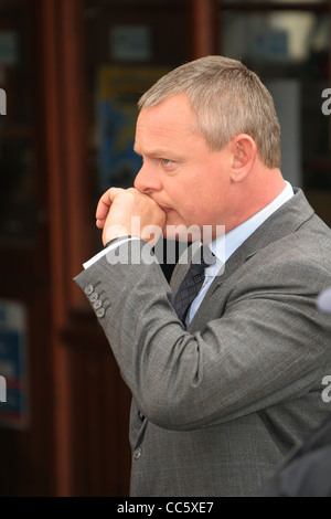 Acteur Martin Clunes sur l'ensemble des Doc Martin à l'extérieur de la station de sauvetage à Port Isaac sur la côte nord des Cornouailles. Banque D'Images