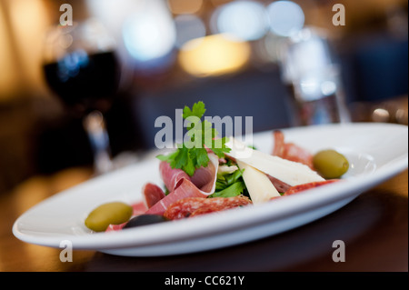 Jambon italien, le fromage et les olives avec un verre de vin rouge Banque D'Images