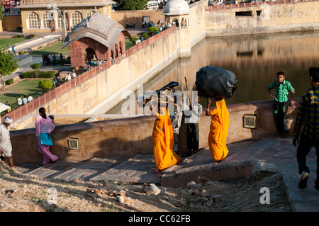 Les femmes en saris transport de lourdes charges sur la tête, Fort Amber Palace, Jaipur, Rajasthan, Inde Banque D'Images