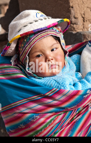 Pérou, Atuncolla.Mère quechua portant son bébé dans une couverture aguayo ou awayu sur son dos, Atuncolla, Pérou. Banque D'Images