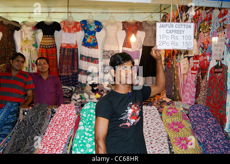 Homme de vente dans un magasin de vêtements en tissu (Boutique) (Exclusive Shop pour capreey coton indien Jaipur ) montrant très bas prix board Banque D'Images