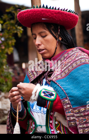 Femme péruvienne dans la robe traditionnelle de la laine de filature à l'atelier artisanal local de coop.Chincheros, Pérou. Banque D'Images