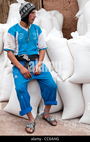 Inca homme assis sur des sacs de sel Salinas de Maras terrasses étangs de sel casseroles mines terrasses, Maras, Vallée Sacrée, Pérou. Banque D'Images