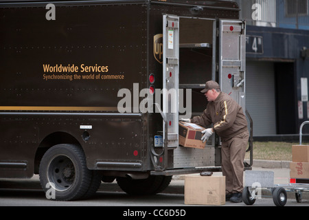 Detroit, Michigan - United Parcel Service pilote se charge paquets dans son camion sur une rue du centre-ville. Banque D'Images