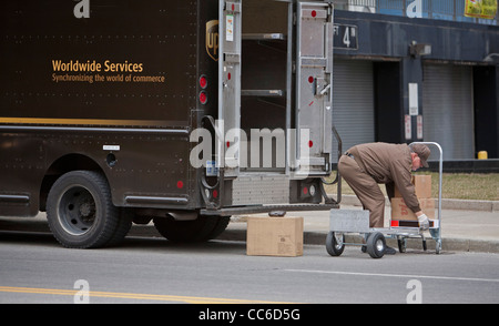 Detroit, Michigan - United Parcel Service pilote se charge paquets dans son camion sur une rue du centre-ville. Banque D'Images