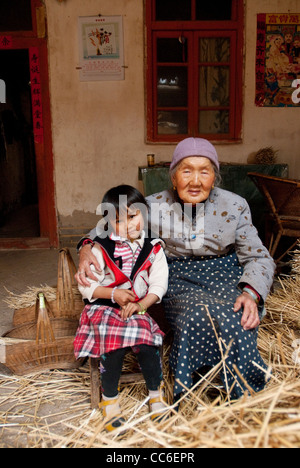 Fille assise avec sa grand-mère, ancienne ville Yi du Yunnan, Xiangyun, Dali, Yunnan, Chine Banque D'Images