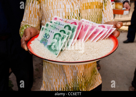 Femme offre l'enfer des billets de banque aux ancêtres, Yangbi, Dali, Yunnan, Chine Banque D'Images