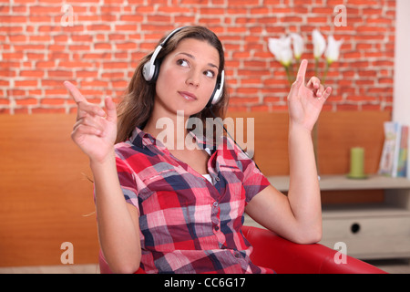 Young woman listening music at home Banque D'Images