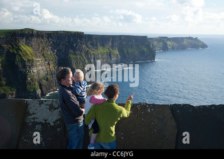 Famille en profitant de la vue sur les falaises de Moher, le Burren, comté de Clare, Irlande. Banque D'Images