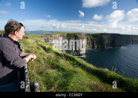 Les touristes profitant de la vue sur les falaises de Moher, le Burren, comté de Clare, Irlande. Banque D'Images