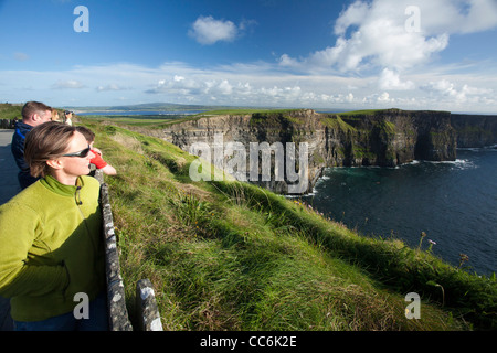 Les touristes profitant de la vue sur les falaises de Moher, le Burren, comté de Clare, Irlande. Banque D'Images