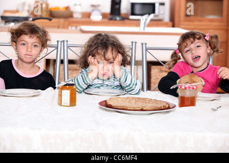 Trois enfants de manger des crêpes Banque D'Images