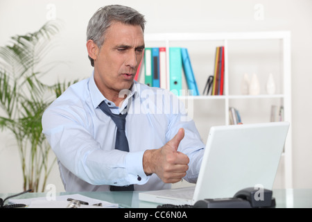 Middle-aged office worker giving thumbs-up Banque D'Images