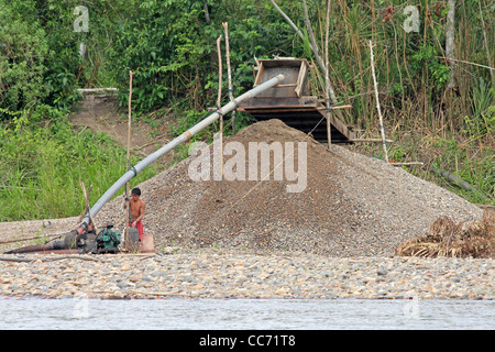 L'AMAZONIE, PÉROU - circa 2011 - novembre péruviens locaux participent à un acte illégal d'extraction de l'or le long d'une rivière amazonienne Banque D'Images