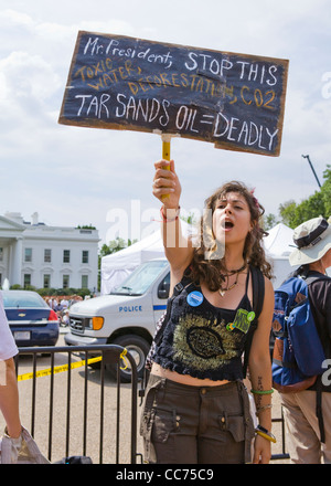 Une femelle manifestant des sables bitumineux holding up un piquet (climat de protestation, manifestant de l'environnement) - USA Banque D'Images