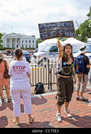 Une femelle manifestant des sables bitumineux holding up un piquet (climat de protestation, manifestant de l'environnement) - USA Banque D'Images