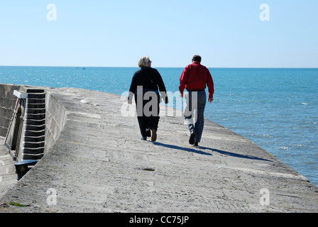 Couple en train de marcher le long de la s/n, Lyme Regis dorset england uk Banque D'Images