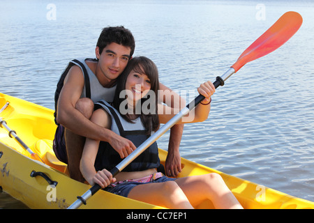 Jeune homme et femme canoë sur un lac Banque D'Images