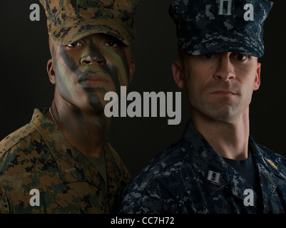 Officier du Corps des Marines des États-Unis en uniforme de camouflage digital MARPAT camo et la peinture pour le visage avec un officier de la marine en uniforme de travail Banque D'Images