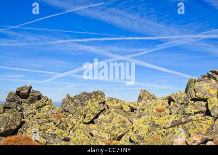 Traverser les nuages de vapeurs de condensation des avions sur le ciel bleu. Banque D'Images