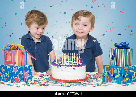 Des jumeaux avec gâteau d'anniversaire et présente Banque D'Images