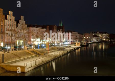 Maisons illuminées sur la rive de la rivière Trave la nuit, ville hanséatique de Lübeck, Schleswig-Holstein, Allemagne, Europe Banque D'Images