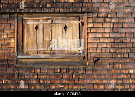 Droit d'une ancienne fenêtre fermée sur une façade en bois teinté Banque D'Images
