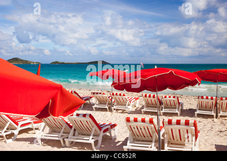 Des chaises et des parapluies rouges le long de la Plage Orient Saint-Martin, French West Indies Banque D'Images