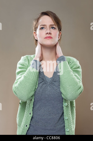 Porrait de fashionable young brunette woman présentant des symptômes de la douleur au cou. Banque D'Images